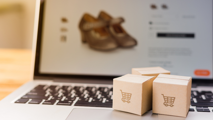 Online Shopping - Paper Cartons Or Parcel With A Shopping Cart Logo On A Laptop Keyboard.